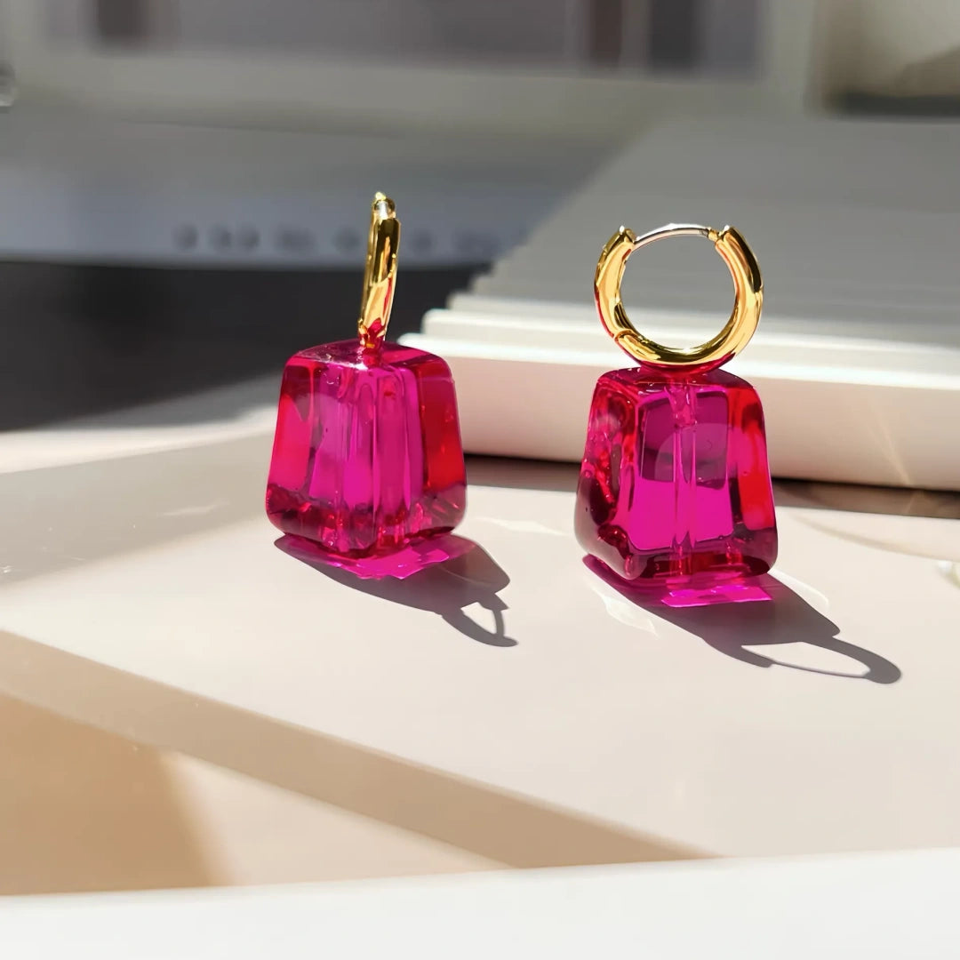 Close up of irregular facets on transparent pink glass jewelry showing light