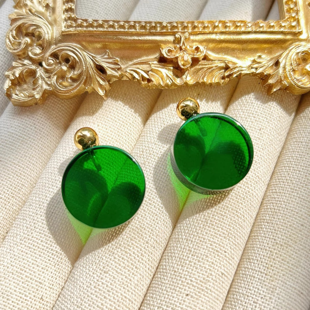 A pair of 2.5cm emerald green glass stud earrings featuring gold ball accents and hypoallergenic stainless steel pins.