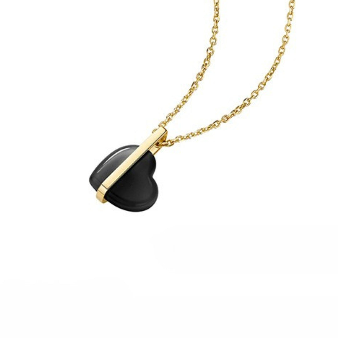 14k yellow gold necklace with a black heart-shaped pendant made of black onyx on a white background