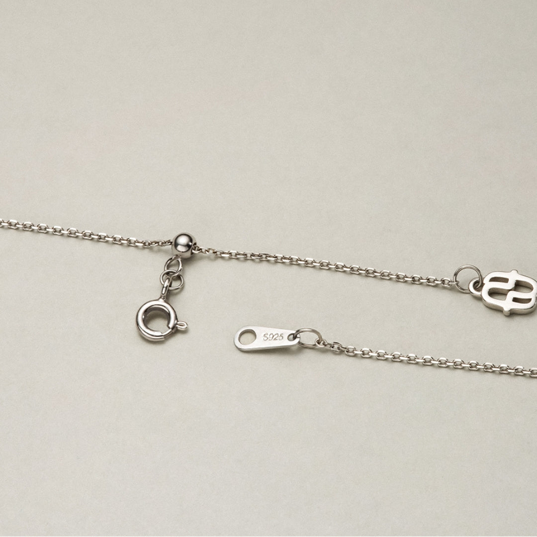 Close-up of a silver chain with clasp on a light gray background