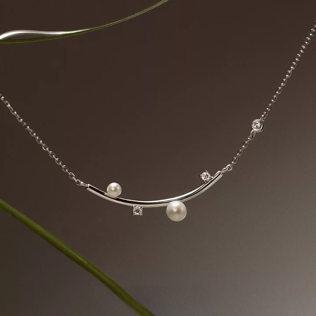 close-up of silver bar pearl necklace with adjustable clasp and zircon accents