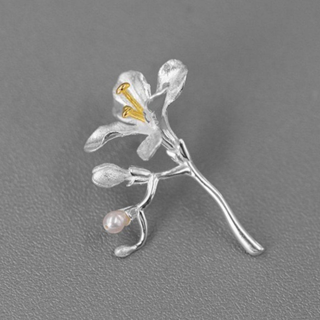 Elegant freesia floral pin with detailed golden stamen and pearl accent in sterling silver.