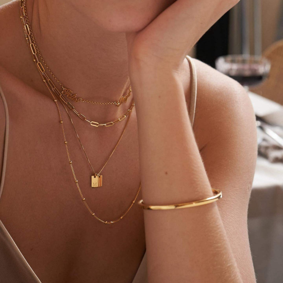 Modern minimalist style featuring a gold-plated custom name necklace on a model, ideal for everyday chic jewelry layering.2
