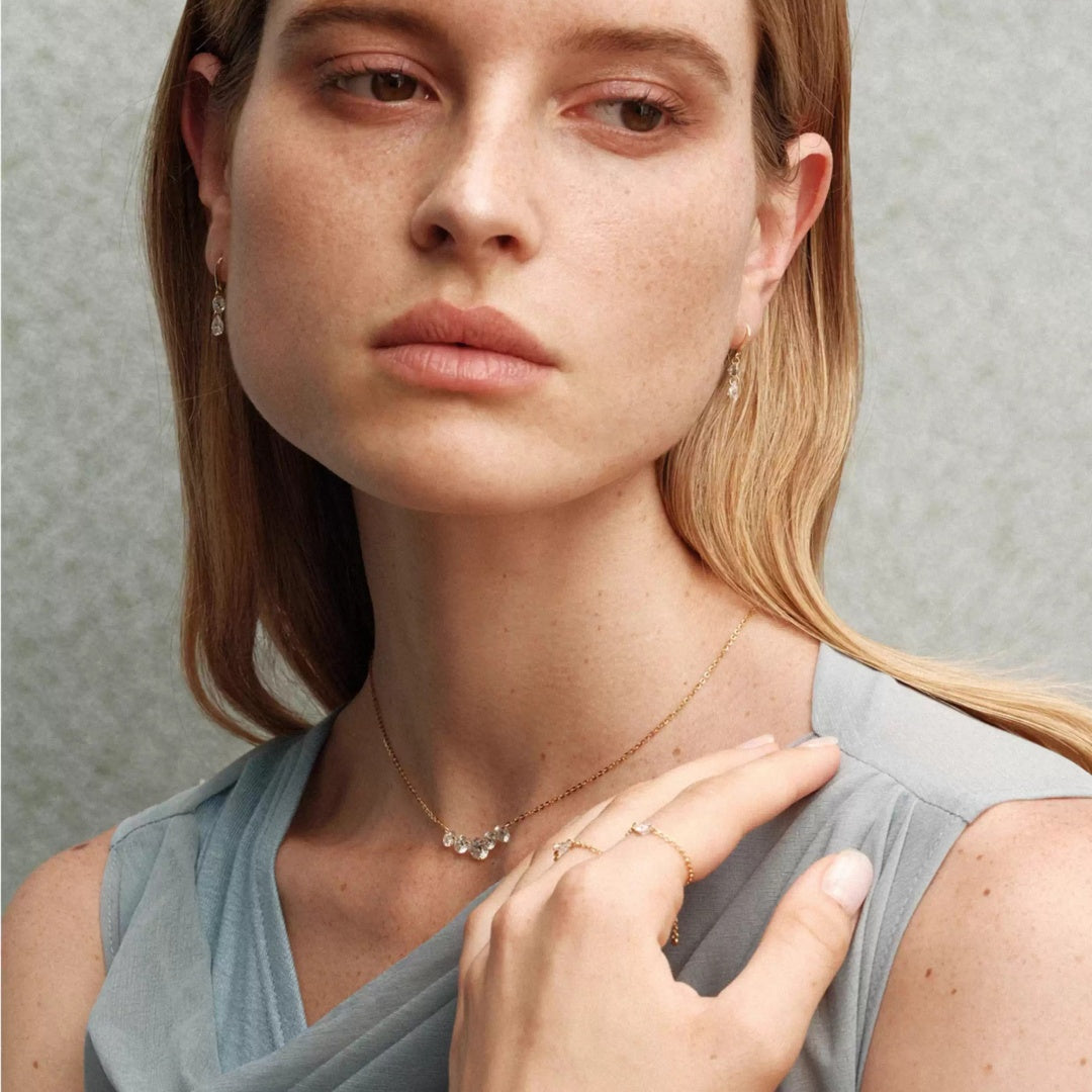 Bride wearing moissanite wedding jewelry set with smile necklace and shimmering pear drop earrings for an elegant bridal look.