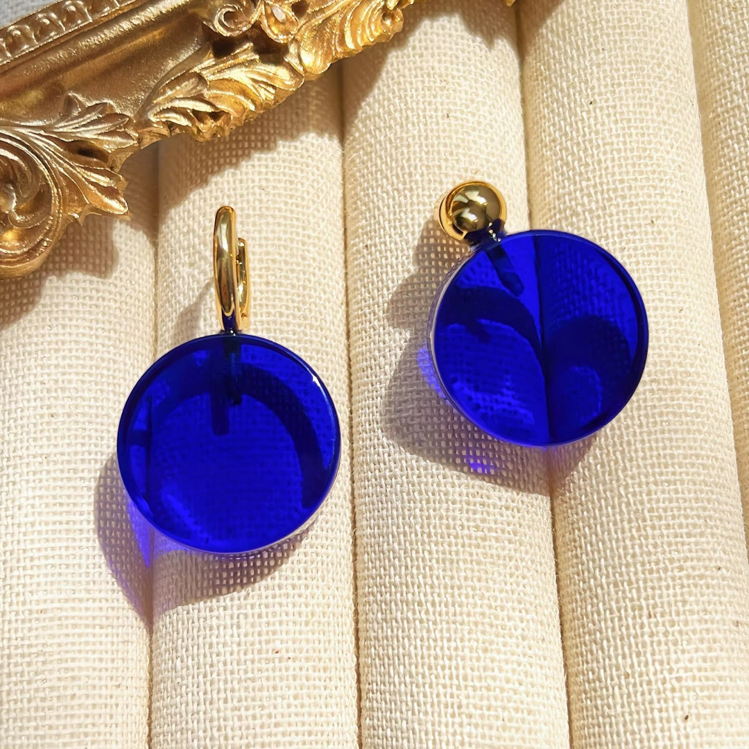 Symmetrical display of electric blue glass earrings with thick 18K gold plating.